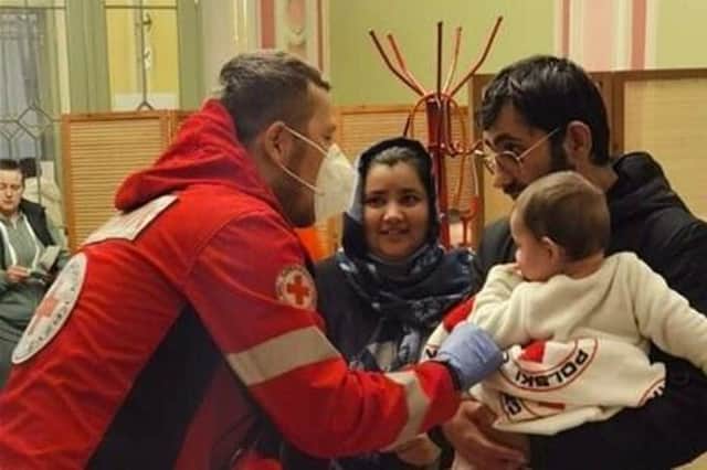 Helping refugees - A Red Cross medic in Poland helping a family newly arrived from Ukraine.