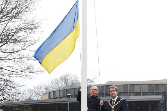 Harrogate Borough Council leader Coun Richard Cooper and Harrogate Mayor Coun Trevor Chapman raise the Ukraine flag.