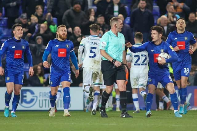 Harrogate Town players show their frustration with referee Darren Handley following his decision to award Tranmere Rovers a second-half penalty during Tuesday night's League Two clash at Prenton Park. Pictures: Matt Kirkham