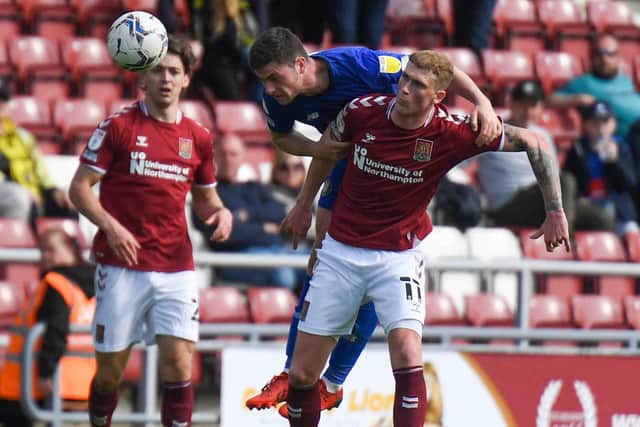 Nathan Sheron beats Northampton's Mitch Pinnock to the ball during Easter Monday's League Two clash at Sixfields.