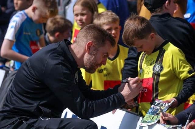 Simon Weaver signs an autograph for a young Harrogate Town fan during the club's 'Supporter Thank You' event, which took place before Saturday's 3-0 home win over Carlisle United. Pictures: Matthew Appleby