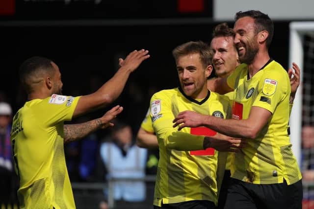 Harrogate Town players celebrate after Rory McArdle, right, headed them into a two-goal lead against Carlisle United.