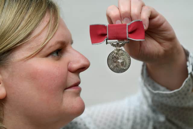 Curator Laura Allan with the British Empire Medal, which was presnted to Leeds City Police Women's Department's Florence Thorley for services to youth in 1971,. Part of the Women in Policing exhibition at the Prison and Police Museum in Ripon. 5th May 2022. Picture : Jonathan Gawthorpe