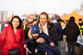 Helping the people of Ukraine - India Hicks carrying a Ukranian child across the Polish border.