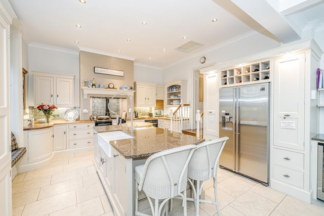 The kitchen features granite worktops, a central island and a range of integrated Miele appliances.