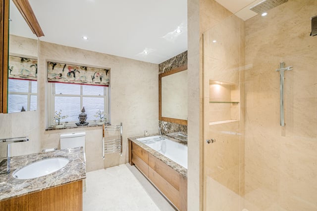 Both the family bathroom and the ensuite to the master bedroom are finished in Carrera marble with bespoke fitted furniture by Room Room.