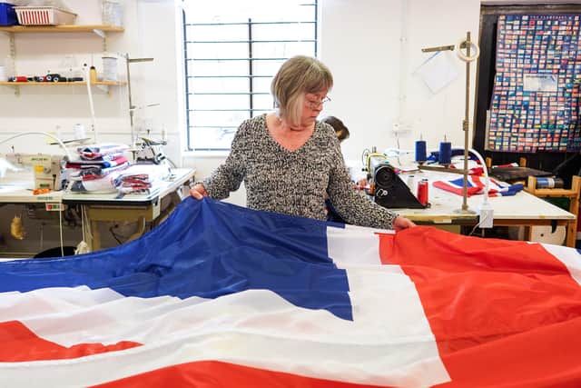 KNARESBOROUGH, ENGLAND - MAY 23: Julie Hamill folds a large Union Flag at the Flying Colours Flagmakers factory on May 23, 2022 in Knaresborough, England. Preparations are taking place across the country ahead of the Queenâ€TMs platinum jubilee celebrations. (Photo by Ian Forsyth/Getty Images)