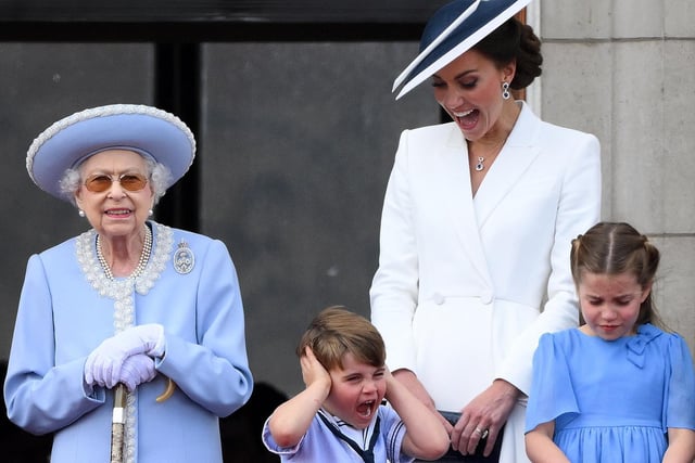 Catherine, Duchess of Cambridge, reacts as Prince Louis of Cambridge covers his ears, as they stand with Queen Elizabeth II and Princess Charlotte of Cambridge to watch a special flypast from the Buckingham Palace balcony.