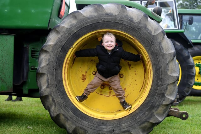Ned Smith (aged four) stood in the wheel of a 8440 John Deere tractor