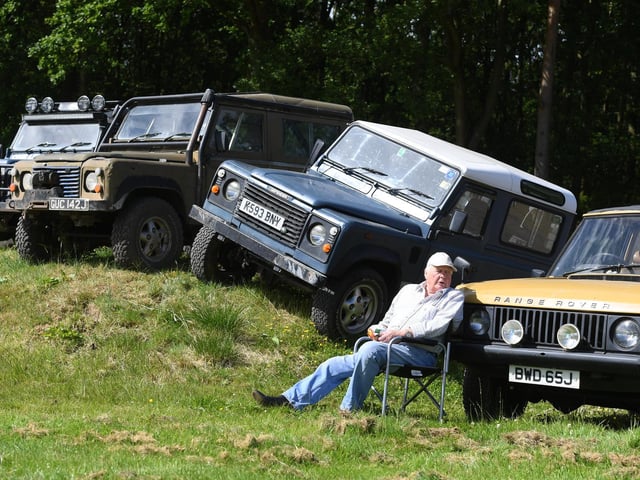 Enjoying the sunshine in front of the Land Rovers on display at the show