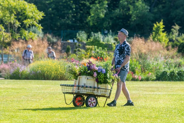 TV Presenter and Floral Designer, Jonathan Moseley, pushing a trolley of flowers across the grounds before the start of the show