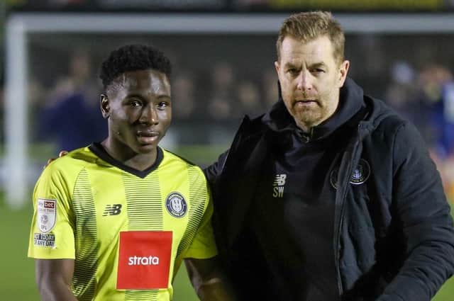 Brahima Diarra, left, is encouraged to go and take the applause of Harrogate Town's fans by Sulphurites boss Simon Weaver. Pictures: Matt Kirkham