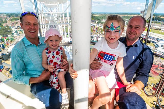 Richard Smith with his daughter Bonnie (aged 2), with friend Ben Mudd and his daughter Ivy (aged 6) enjoying the views of the show from the top of the giant ferris wheel