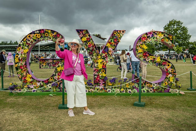 Anne Powley takes a selfie in front of the GYS floral display