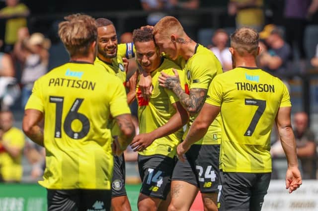 Lewis Richards, centre, is congratulated by his Harrogate Town team-mates after firing the Sulphurites into a 26th-minute lead against Huddersfield Town. Pictures: Matt Kirkham