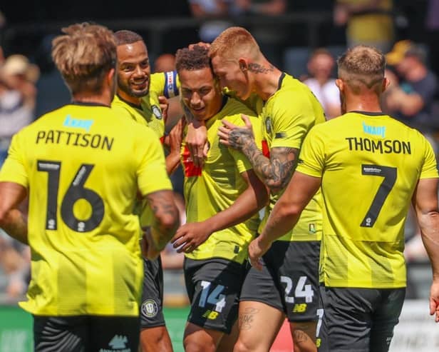 Lewis Richards, centre, is congratulated by his Harrogate Town team-mates after firing the Sulphurites into a 26th-minute lead against Huddersfield Town. Pictures: Matt Kirkham