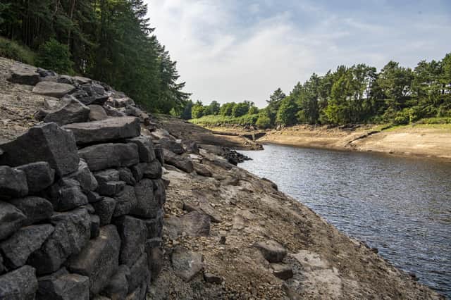 19 July 2022........ The submerged walls of buldings and boundary walls aswell as the stumps of felled trees emerge from the low water levels at Thruscross Reservoir near Harrogate as the long spell without significant rainfall continues. Picture Tony Johnson