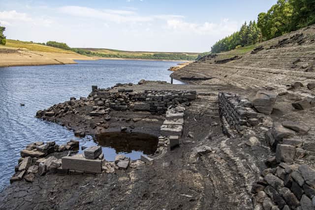 19 July 2022........ The submerged walls of buldings and boundary walls aswell as the stumps of felled trees emerge from the low water levels at Thruscross Reservoir near Harrogate as the long spell without significant rainfall continues. Picture Tony Johnson