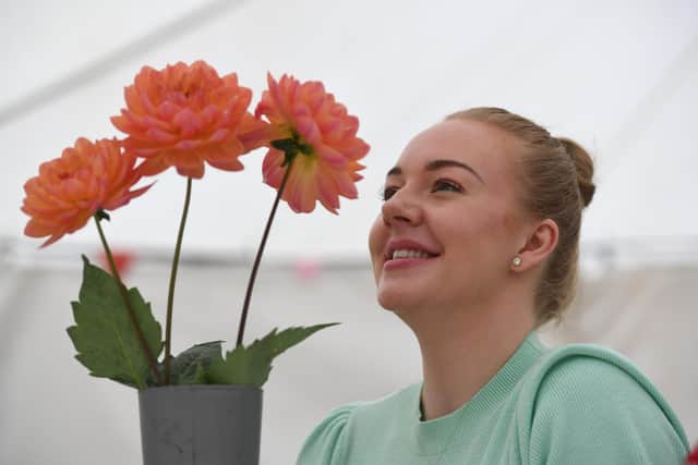 Harriet Parker with the first prize-winning Dahlias entered by Roger Dawson at Birstwith Show. (Picture Gerard Binks)