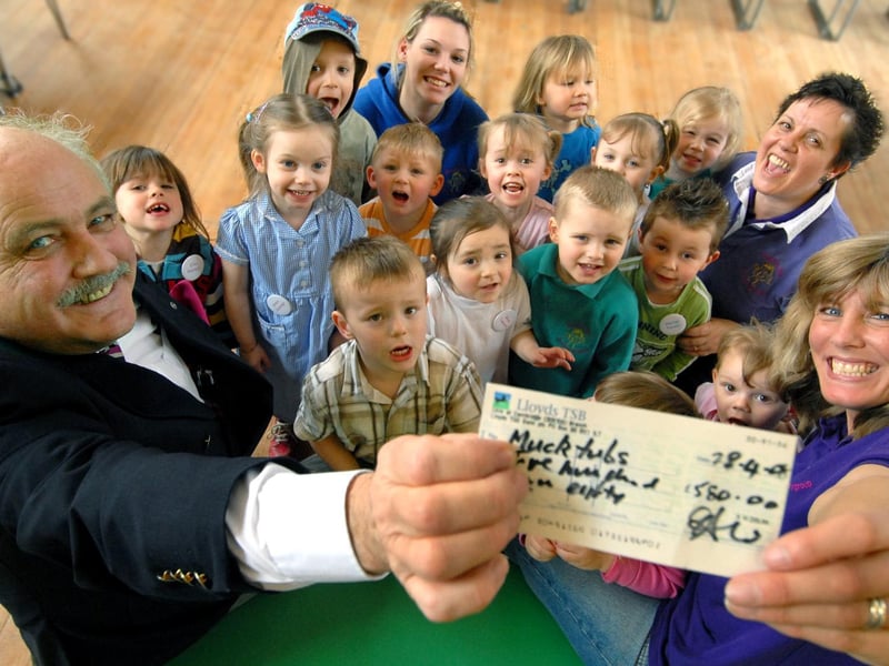 Mucktubs Preschool Playgroup children cheer as Scarborough Cavalier Howard Donlan presents Debbie Ioanna with a cheque.