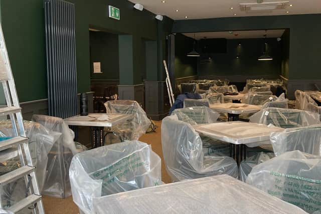 The restaurant has been painted green and features new seating for customers.