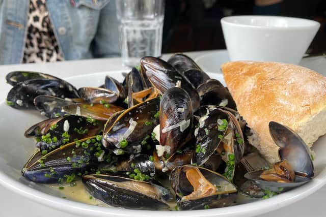 A hearty starter portion of moules mariniere, finished with a chunk of crusty white bread to mop up the creamy sauce.