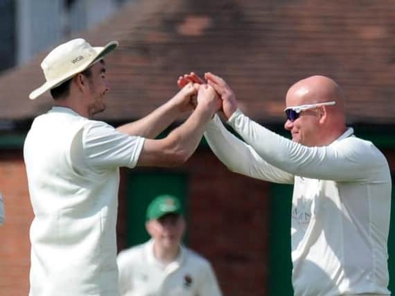 Harrogate CC skipper Will Bates, left, congratulates spinner Dominic Bradburne, who took three wickets during Saturday's win against York. Picture: Gerard Binks