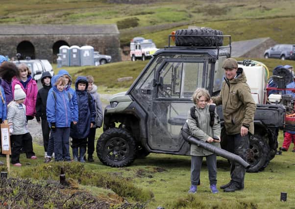 Game keeper Dan Place talk with 9-year-old Eddie Harrison of Hackforth and Hornby School at the 'Let's Learn Moor' event near Grinton on the Yorkshire Moors.