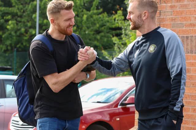 Mark Oxley, left, is greeted by Town manager Simon Weaver upon his arrival for the first day of pre-season training.