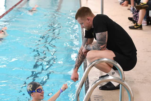 Olympic medal hero Adam Peaty passes on his expertise to a young swimmer at Ashville College.