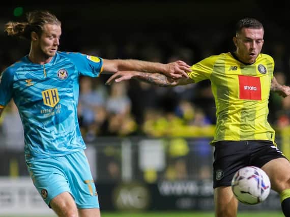 Harrogate Town defender Lewis Page is challenged by Newport's Alex Fisher. Pictures: Matt Kirkham