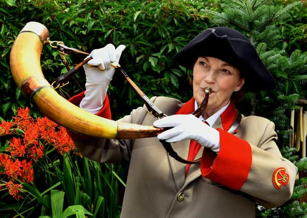 Allison Clark one of the Ripon hornblowing team keeping the tradition going by blowing the  1690 horn in her Ripon garden .