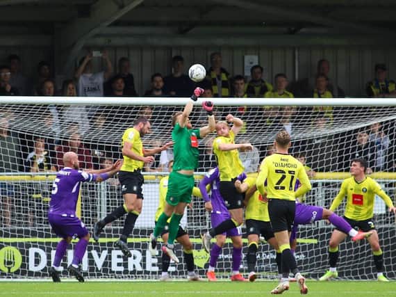 Harrogate Town goalkeeper Mark Oxley punches the ball to safety. Pictures: Matt Kirkham
