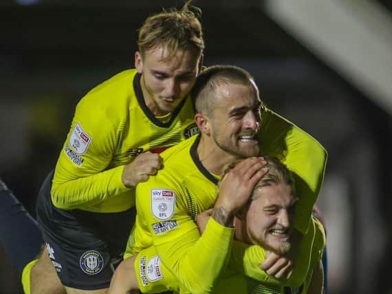 Jack Diamond, left, and Alex Pattison congratulate Luke Armstrong, right, after he put Harrogate Town 2-1 up against Tranmere Rovers. Pictures: Matt Kirkham