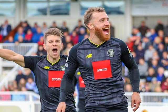 George Thomson, right, celebrates after firing Harrogate Town into a 28th-minute lead at the Victoria Ground.