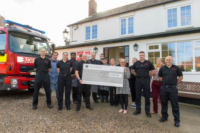The Gill family presented the firefighters who helped tackle the blaze with a £5,000 cheque for the Fire Fighters Charity