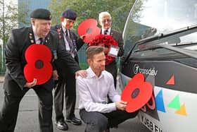 From left, veterans Geoff Lister, Michael Scott and Keith Webster watch as engineer Jonathan Ruston fits a poppy to one of the company’s buses