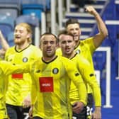 Harrogate Town players celebrate their last-gasp winner at Portsmouth. Pictures: Matt Kirkham
