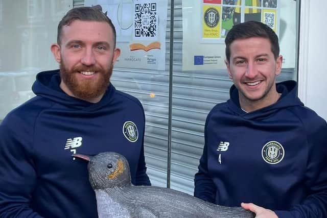 Harrogate Town Midfielders Josh Falkingham and George Thomson reveal Isobel Trigoso’s winning Percy the Penguin window design and Harry Gator’s fabulous Away Shirt discount