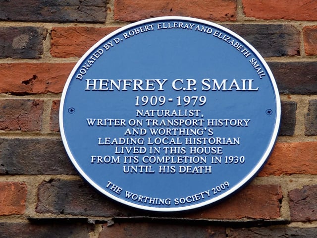 The blue plaque for Henfrey Smail. He is especially remembered for various volumes he wrote on aspects of the town's history. He was interested in archaeology and botany and helped set up the Sussex Wildlife Trust.