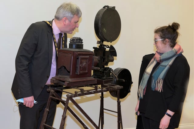 Museum Services Officer Sarah Carson shows the Mayor of Causeway Coast and Glens Borough Council Councillor Richard Holmes a projector used to show silent films in St Patrick’s Hall Ballymoney