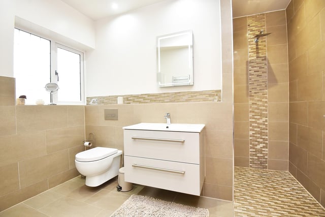 A walk-in shower and wash basin with vanity unit feature in this facility.