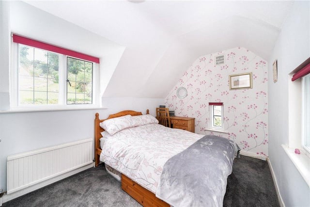 This bright bedroom has a quirky shape, with a little side window adding further character.