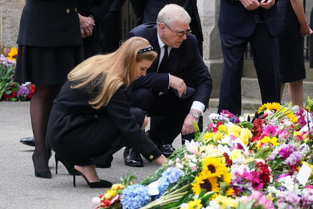 Prince Andrew, Duke of York and Princess Beatrice of York look at messages and floral tributes left by members of the public after attending a service at Crathie Kirk church near Balmoral following the death of Queen Elizabeth II. (Photo by Owen Humphreys-WPA Pool/Getty Images)