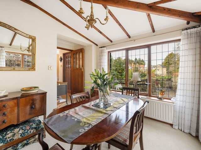 The beamed dining room has a lovely outlook over the river.