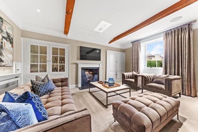 A beamed reception room with feature fireplace.