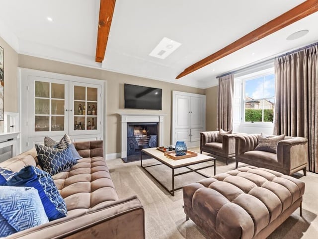 A beamed reception room with feature fireplace.