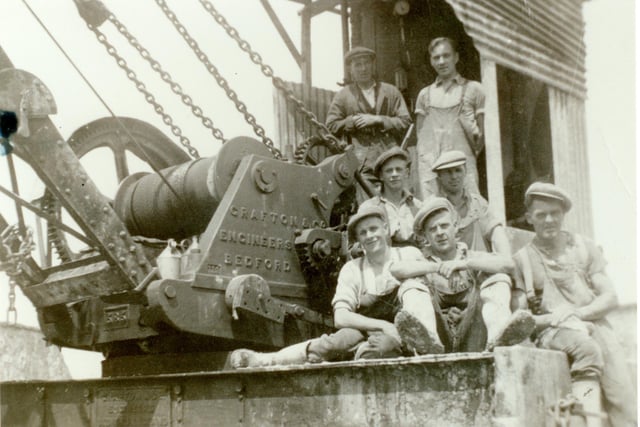 Workers posing on a steam crane or shovel.