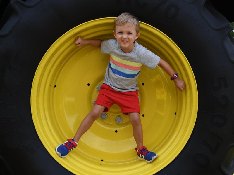 Elwin Blackie (aged four) stood in the wheel of a tractor