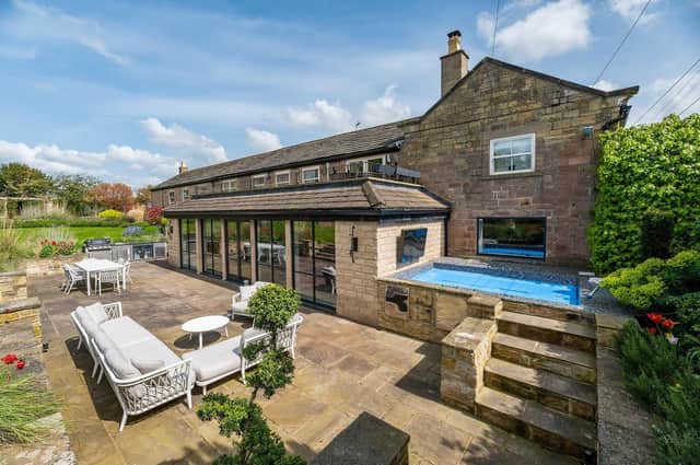 The house has lawned and landscaped gardens of over an acre, with seating areas, and a tennis court.